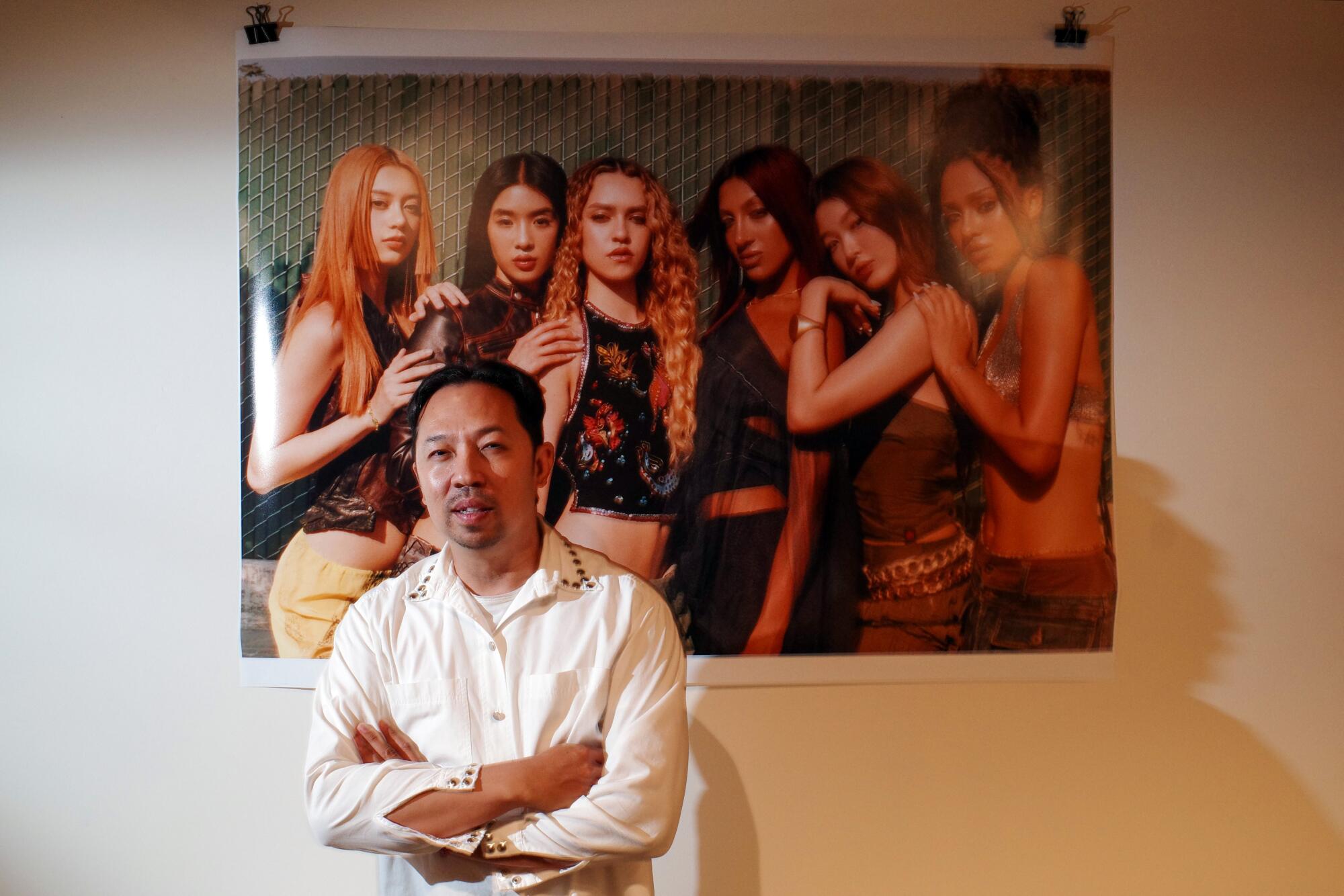 Humberto Leon poses with a portrait of global girl group Katseye