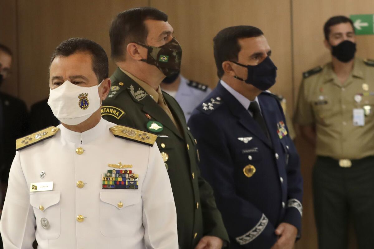 Brazil’s new military commanders, Navy commander Admiral Almir Garnier, left, Army commander General Paulo Sergio, center, and Air Force commander Brigadier Carlos de Almeida Baptista Jr., right, stand during their presentation ceremony at the Ministry of Defense headquarters in Brasilia, Brazil, Wednesday, March 31, 2021. The new leaders of all three branches of Brazil's armed forces were named after the previous ones jointly resigned following President Jair Bolsonaro's replacement of the defense minister, causing widespread apprehension of a military shakeup to serve the president's political interests. (AP Photo/Eraldo Peres)