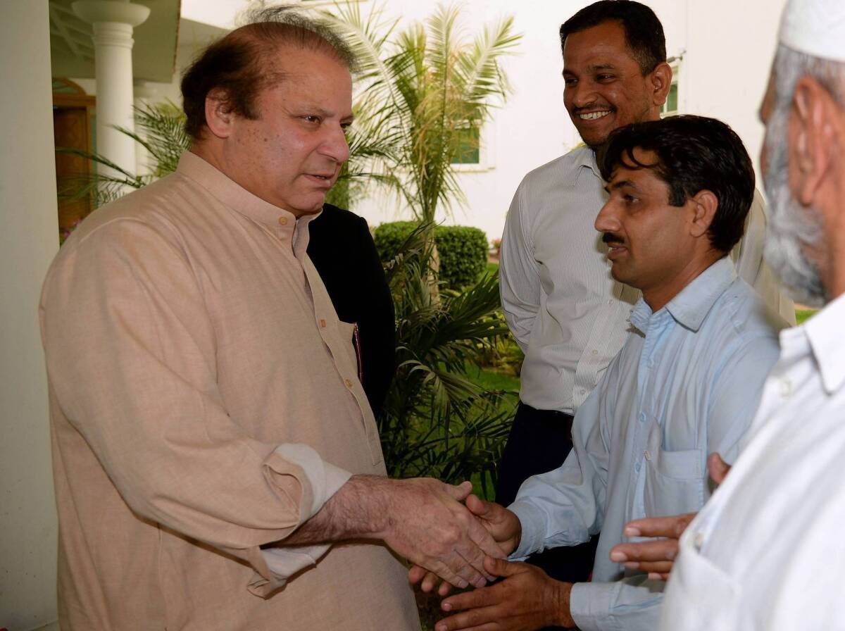 Former Pakistani Prime Minister Nawaz Sharif, left, meets with party supporters in Lahore. With his party's clear margin of victory in elections, he is expected to become prime minister for an unprecedented third time.