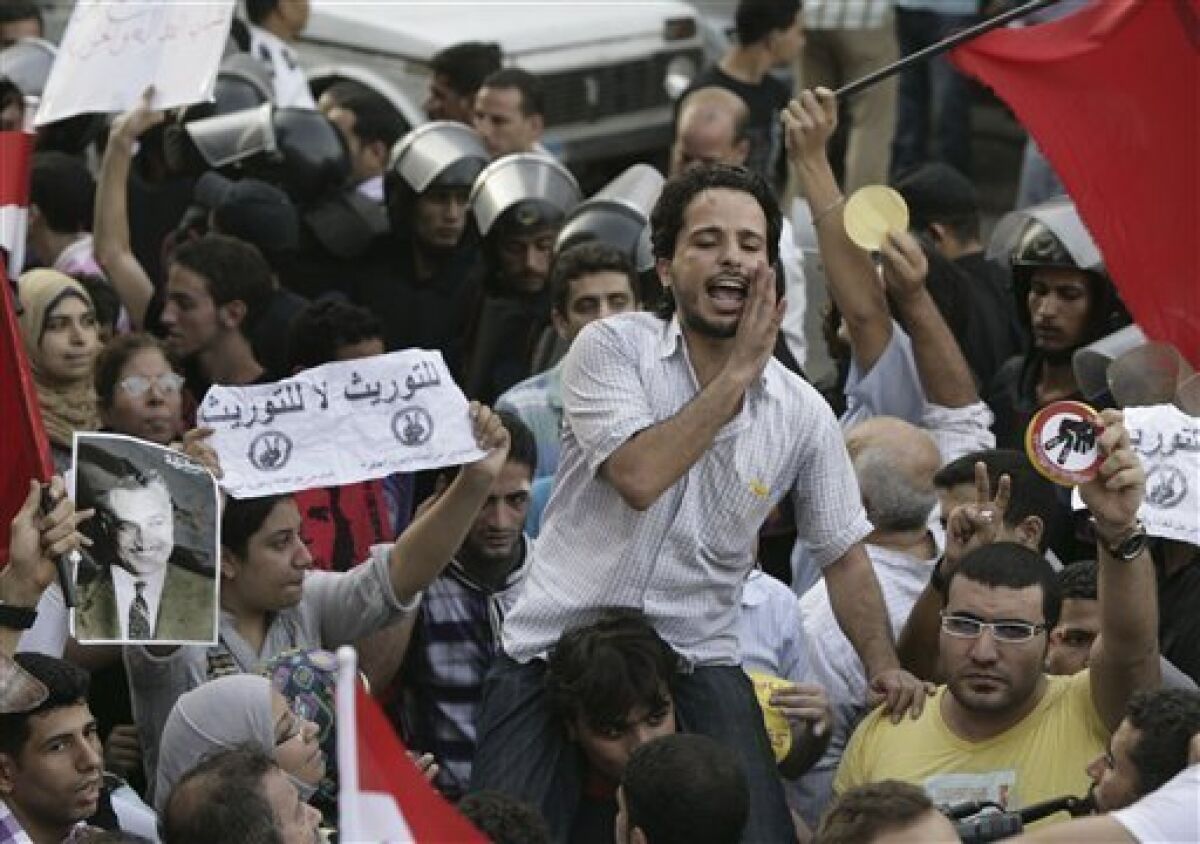 Egyptian activists shout anti - succession slogans during a protest in Cairo, Egypt, Tuesday, Sept. 21, 2010. Egyptian police beat and arrested anti-government activists demonstrating outside the downtown presidential palace against a possible father-son succession in the country. Arabic read " No for succession ". (AP Photo)