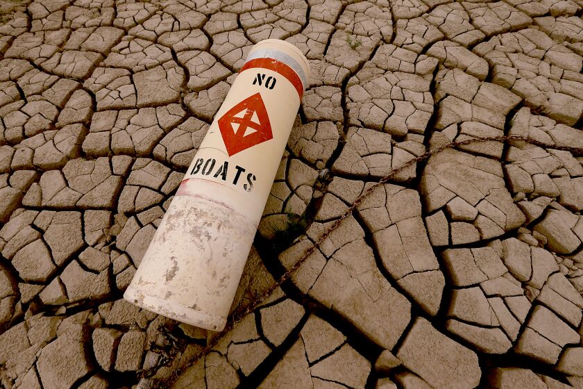 LAKE MEAD NATIONAL RECREATION AREA , NEV. - AUG. 23, 2022. A navigation bouy lies on the cracked bed of Lake Mead near the Boulder Boat Launch as the water continues to recede in the nation's largest reservoir. The lake stores water from the Colorado River, which is allocated to millions of people in the river's lower basin. ( Luis Sinco / Los Angeles Times)