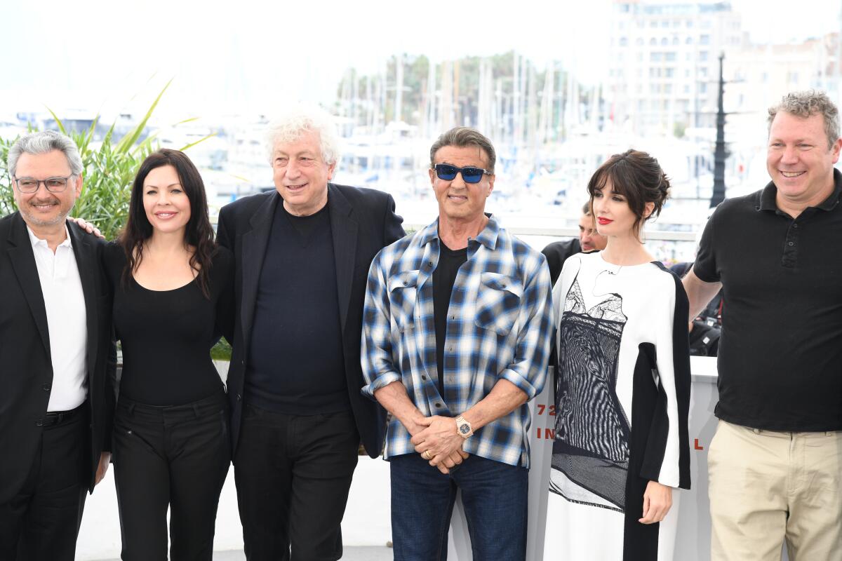 Sylvester Stallone poses with a group of people 