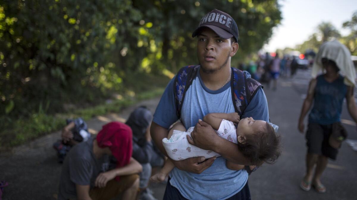 Honduran migrant Oscar Hernandez, 22, carries his 11-month-old daughter, Daniela, in the southern Mexican state of Chiapas on Oct. 30.