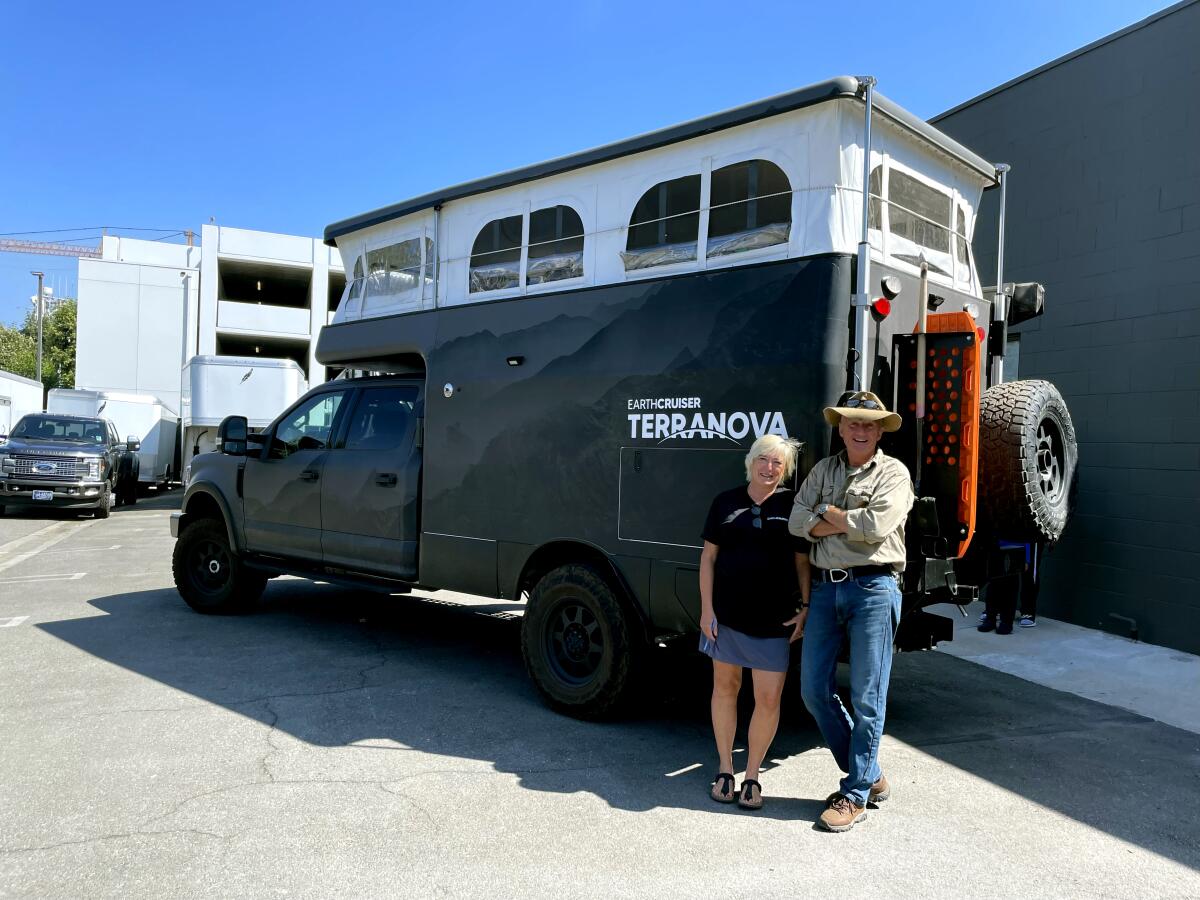 EarthCruiser founders Michelle Boltz and Lance Gillies next to an overland expedition vehicle.