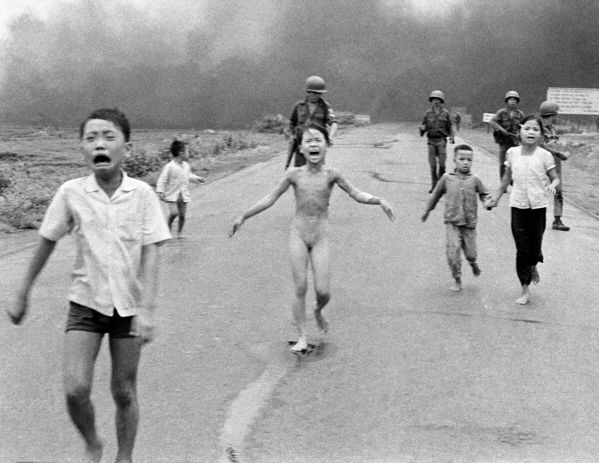 FILE - South Vietnamese forces follow terrified children, including 9-year-old Kim Phuc, center, as they run down Route 1 near Trang Bang after an aerial napalm attack on suspected Viet Cong hiding places on June 8, 1972. A South Vietnamese plane accidentally dropped its flaming napalm on South Vietnamese troops and civilians, and the terrified girl had ripped off her burning clothes while fleeing. (AP Photo/Nick Ut, File)