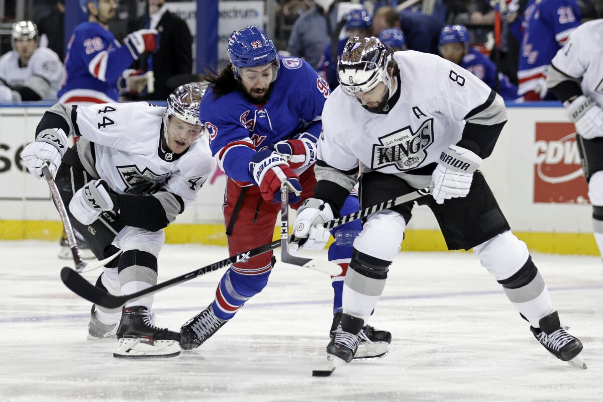 Kings defenseman Drew Doughty, right, takes the puck from New York Rangers forward Mika Zibanejad.