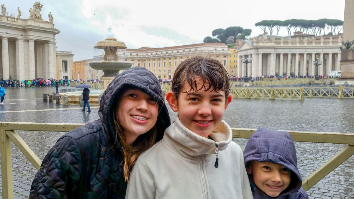 Three kids near the end of a 45-minute wait in April showers to enter St. Peter's Basilica.