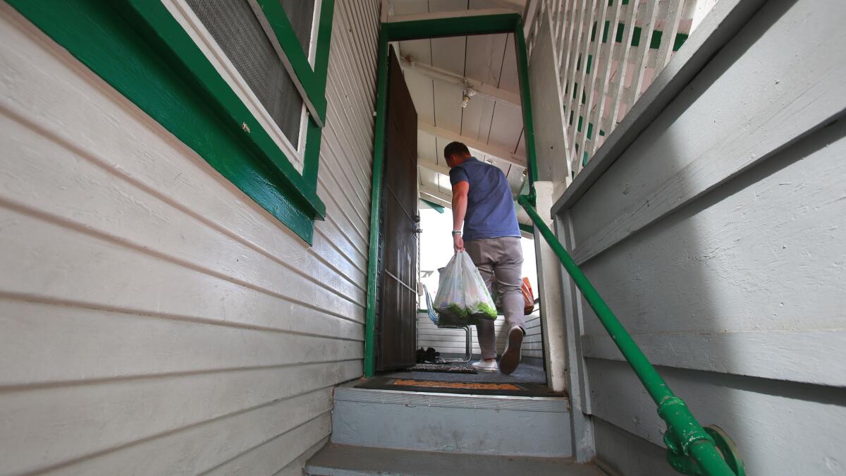 Assembly Bill 1482 could limit how much rents can increase in a year. Pictured: A man enters his apartment in Little Italy.
