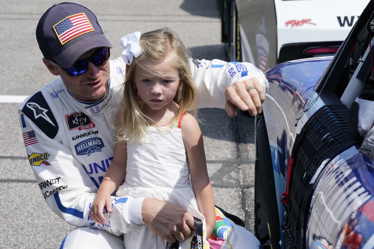 Dale Earnhardt Jr., holds his daughter Isla, 3, during driver introductions prior to the start of the NASCAR Xfinity auto race in Richmond, Va., Saturday, Sept. 11, 2021. (AP Photo/Steve Helber)