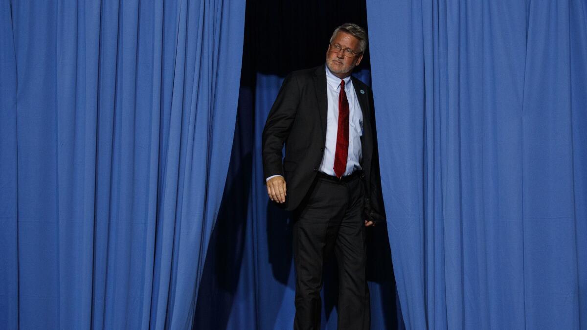 The man behind the curtain: White House communications director Bill Shine offstage Oct. 2 a Trump rally in Southaven, Miss.