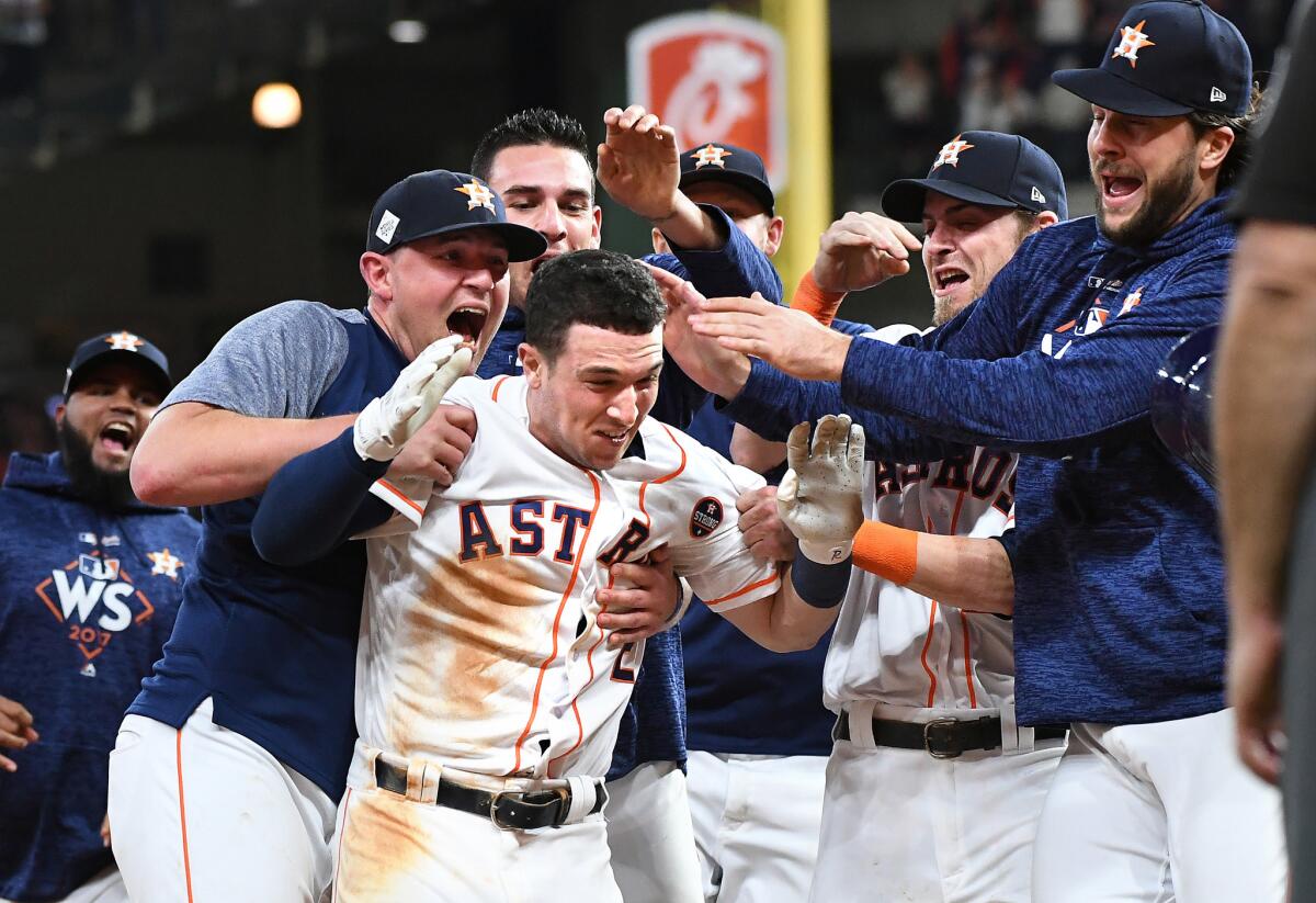 HOUSTON, TEXAS OCTOBER 29, 2017-Astros Alex Bregman is mobbed by teammates after hitting the game winner against the Dodgers in the 10th inning in Game 5 of the World Series at Minute Maid Park in Houston Sunday. (Wally Skalij/Los Angeles Times)