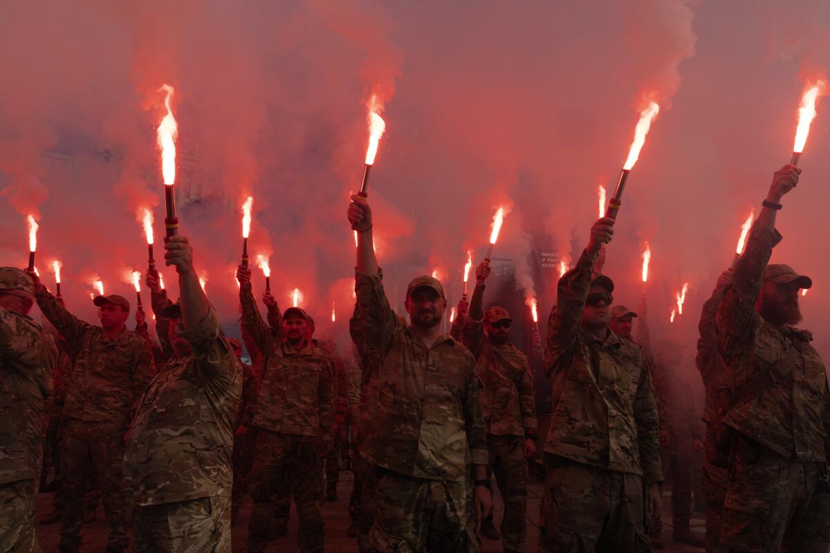 Soldados del batallón Azov de Ucrania encienden bengalas durante una manifestación 