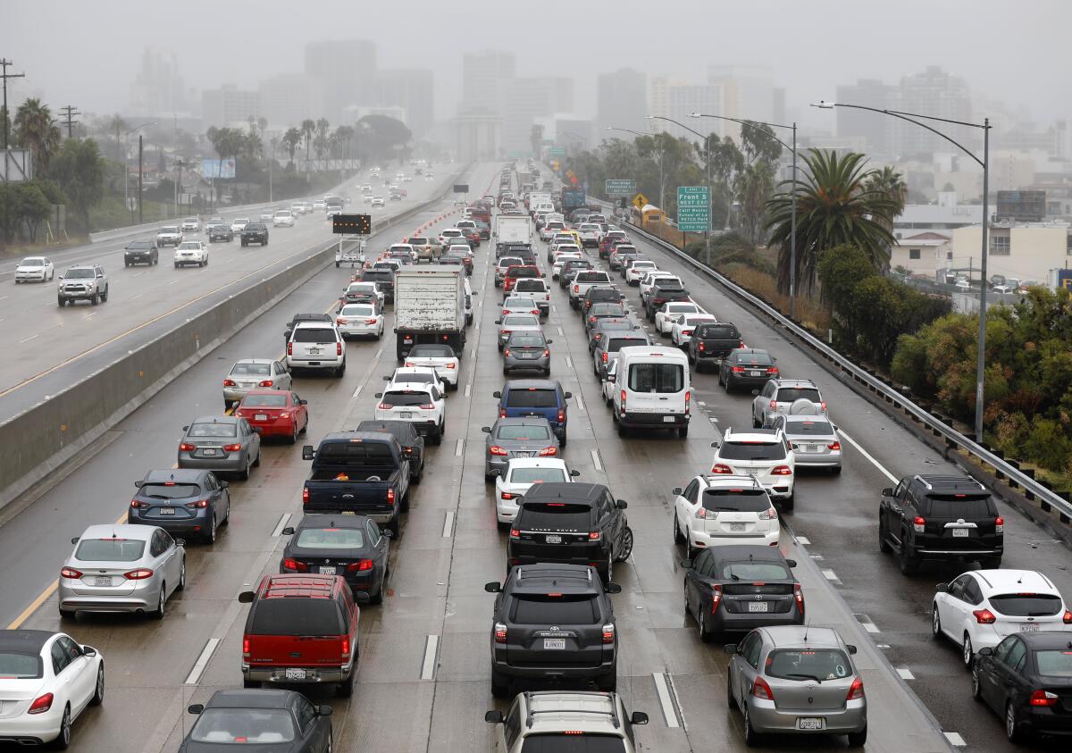 Fog envelops buildings in downtown San Diego as traffic backed up on southbound Interstate 5 