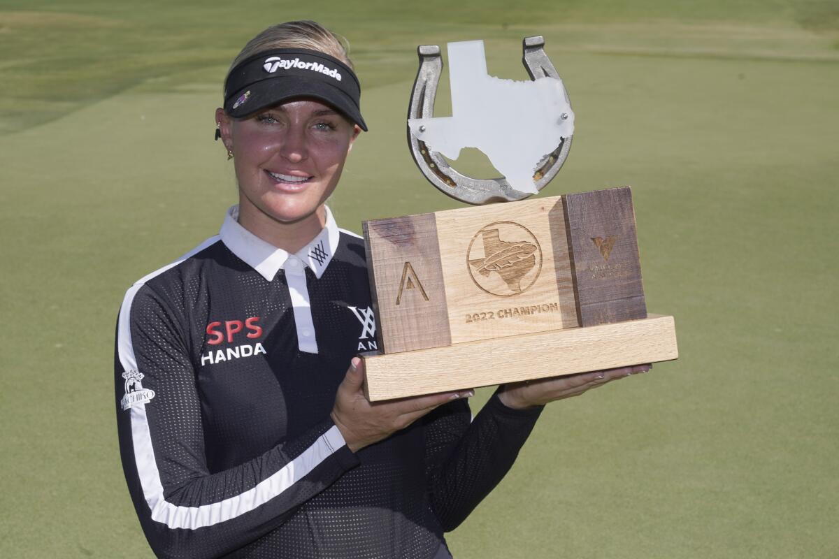 Charley Hull, of England, poses with the champion's trophy after winning the LPGA The Ascendant golf tournament in The Colony, Texas, Sunday, Oct. 2, 2022. (AP Photo/LM Otero)