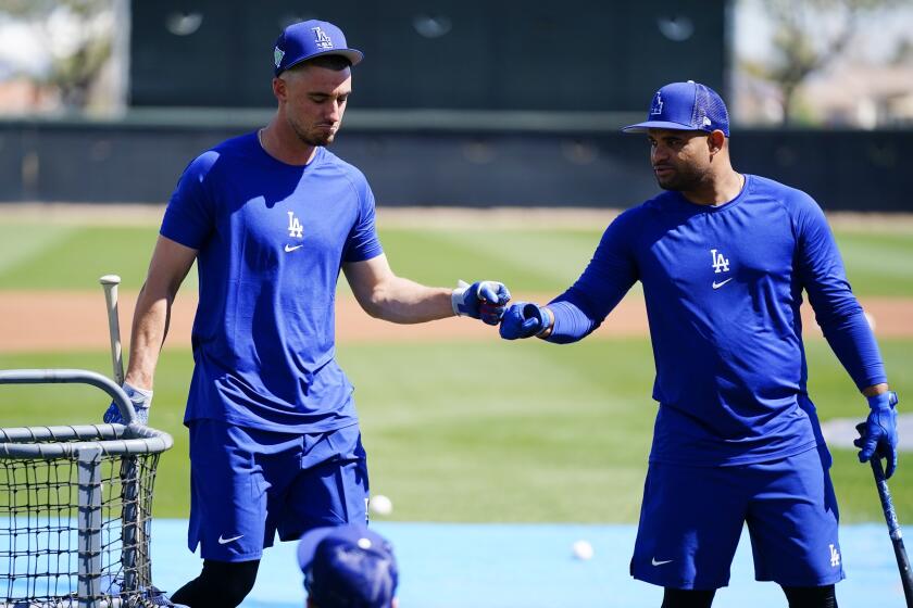 Los Angeles Dodgers' Cody Bellinger, left, gives a fist bump to Tomas Telis.