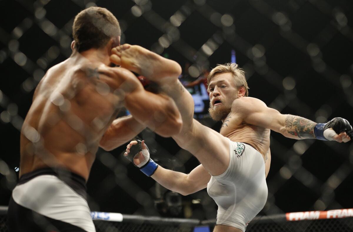 Conor McGregor lands a kick against Chad Mendes during their interim featherweight title fight at UFC 189.