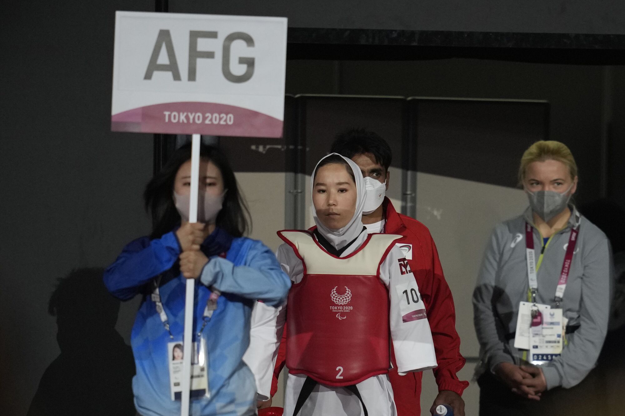 Afghanistan's Zakia Khudadadi, center, enters the competition venue prior to her Taekwondo match.