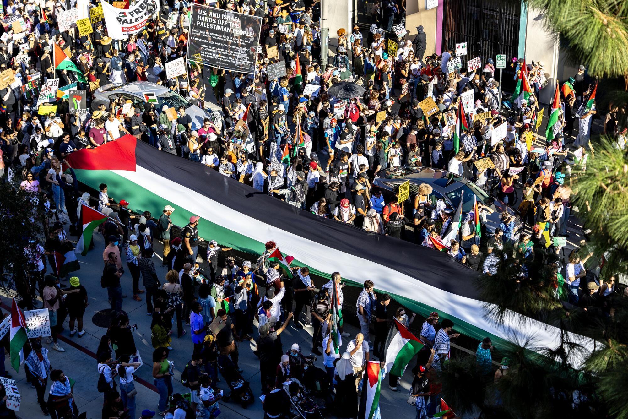 Los manifestantes llevan una bandera palestina gigante por una calle. 
