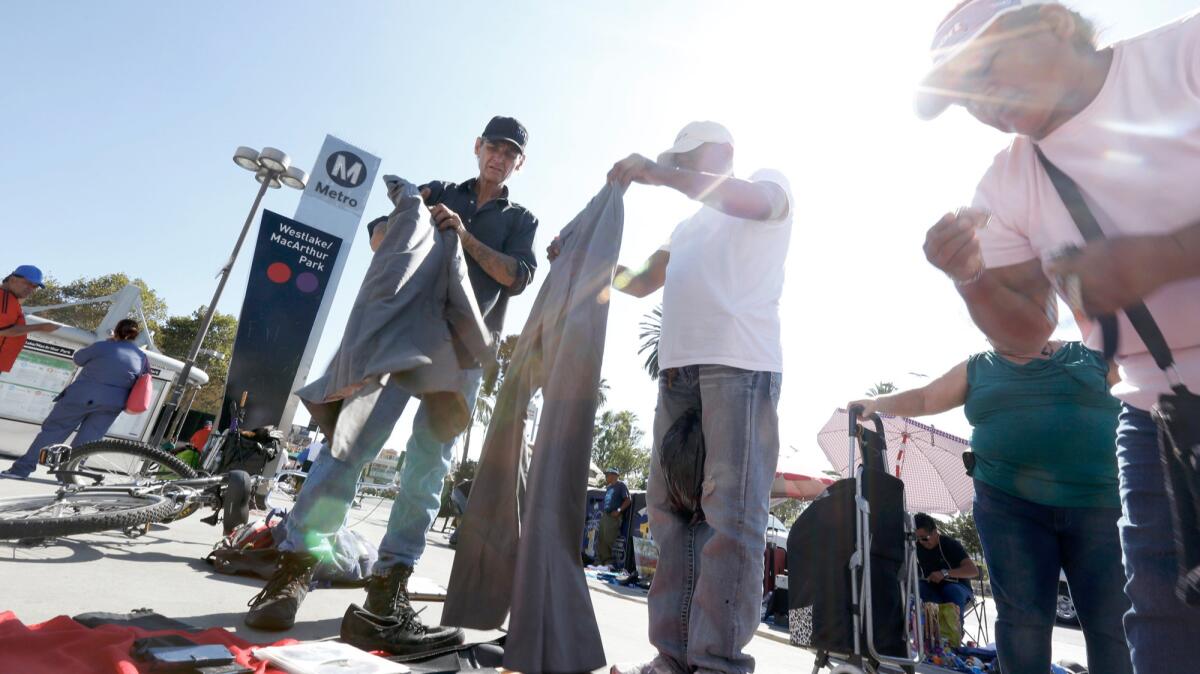 Kevin "Sippi" Moran, 49, left, in black baseball cap, has been homeless for two years and a sidewalk vendor for the past six months.