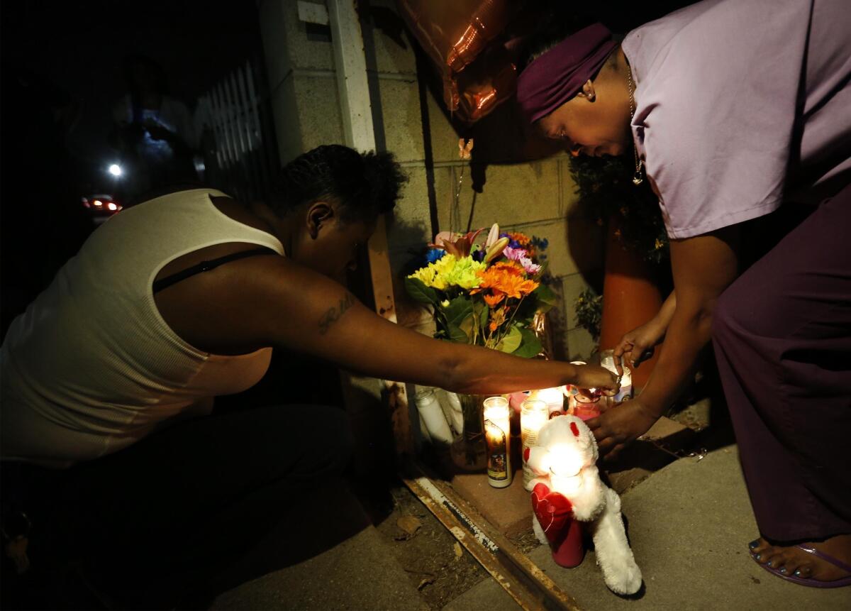 Lele Bowden and Toni Bowden light candles at a memorial for Autumn Johnson, a Compton 1-year-old who was killed by gunfire.