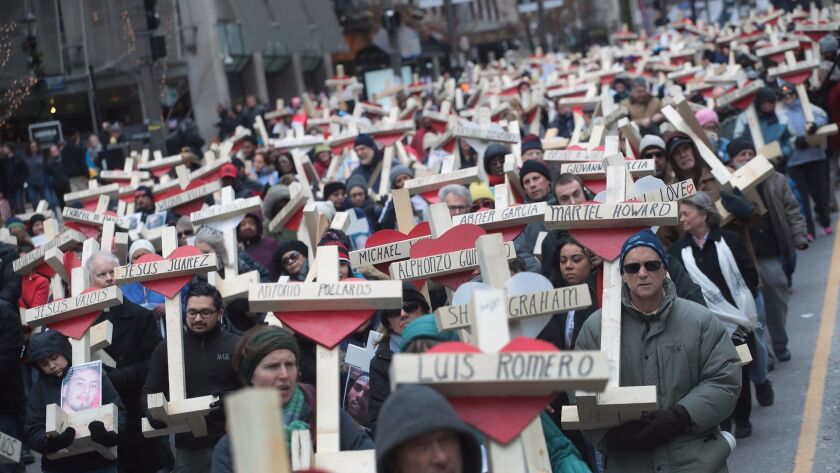 Residents, activists, friends and family members of victims of gun violence march in Chicago on Dec. 31, 2016, carrying nearly 800 wooden crosses bearing the names of people killed in the city in 2016.