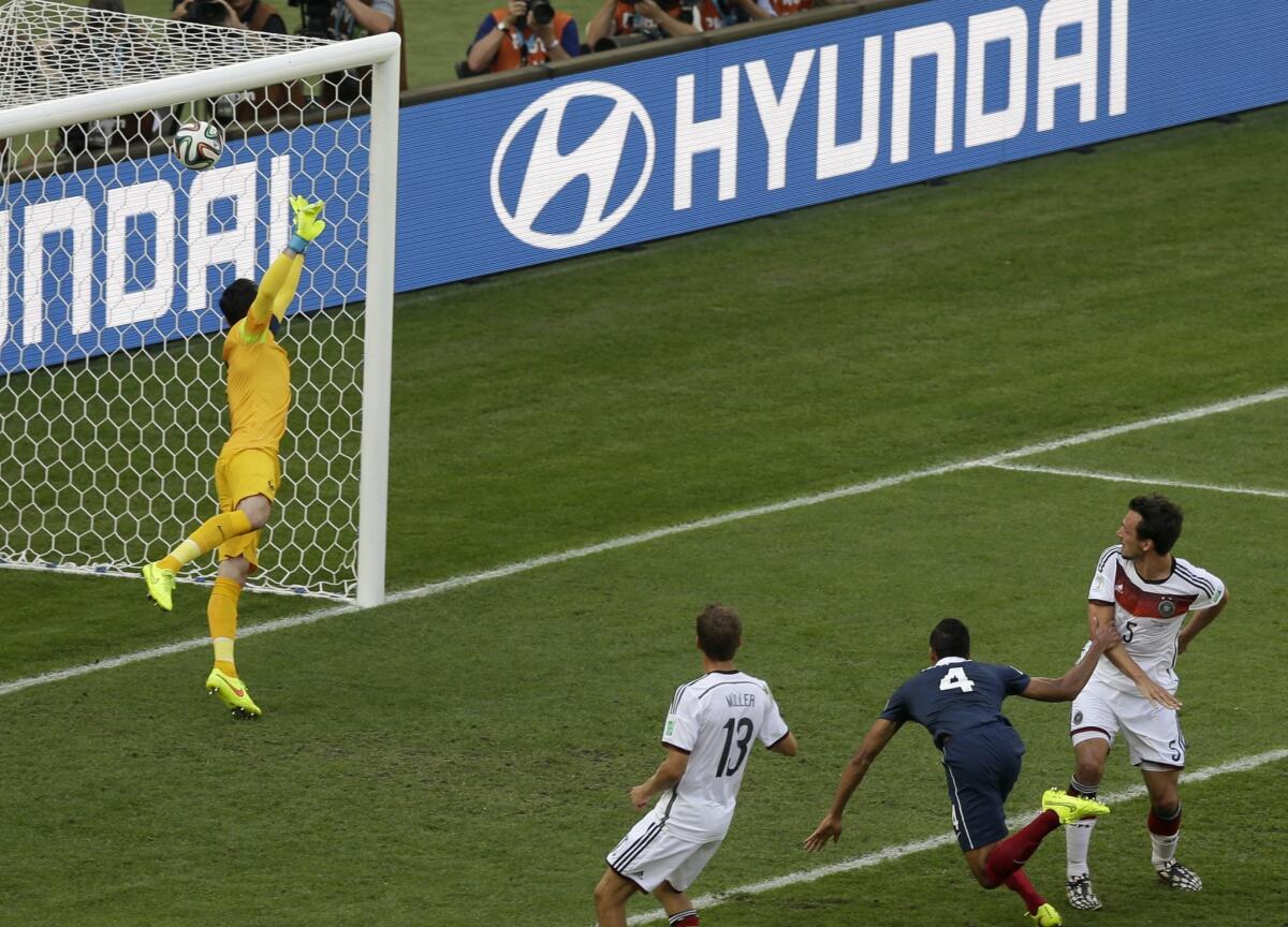 Germany's Mats Hummels, right, scores past France goalkeeper Hugo Lloris.