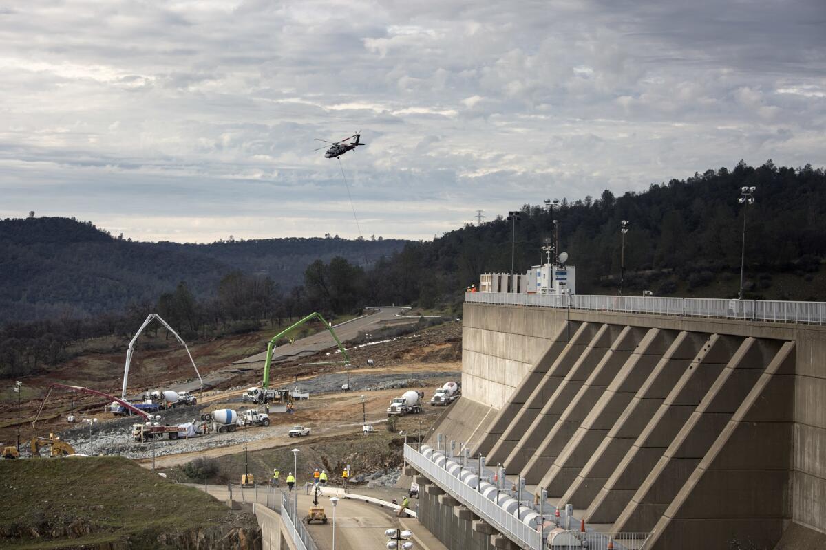 Reconstruction continues in a race to shore up the emergency spillway, left, at Oroville Dam on Wednesday.