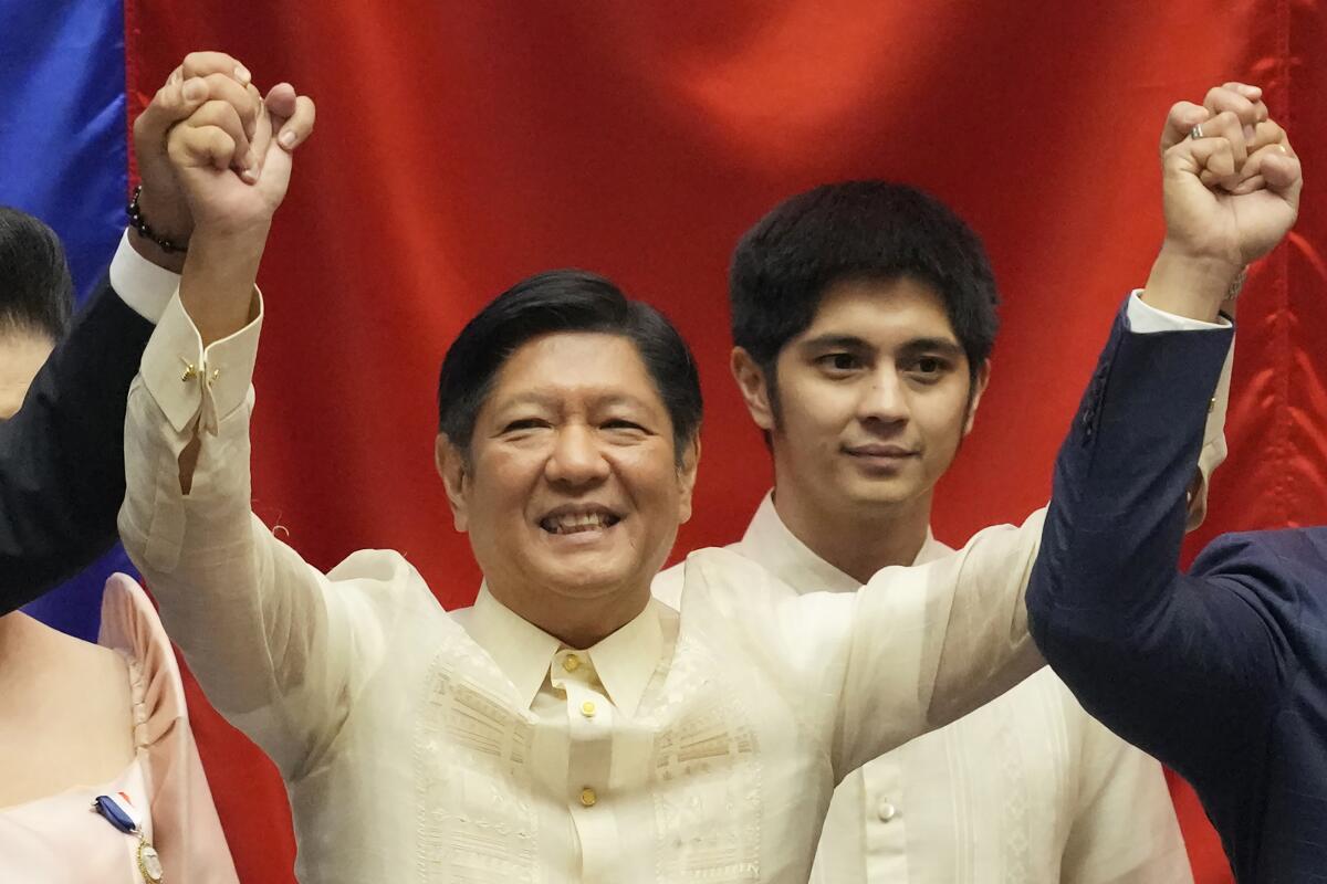 FILE - President-elect Ferdinand "Bongbong" Marcos Jr. raises hands with Senate President Vicente Sotto III, left, and House Speaker Lord Allan Velasco during his proclamation at the House of Representatives, Quezon City, Philippines on May 25, 2022. A top State Department official met Thursday, June 9, 2022 with Marcos in Manila, part of an ongoing diplomatic outreach in the Asia-Pacific region that Washington has undertaken to try and blunt growing Chinese influence. (AP Photo/Aaron Favila, File)