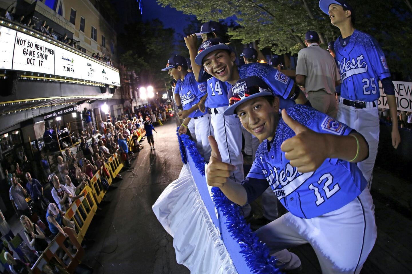 Members of the Sweetwater Valley Little League all-stars team ride in parade in downtown Williamsport, Pa., on Wednesday night. In the foreground is Sweetwater Valley player Ariel Armas.