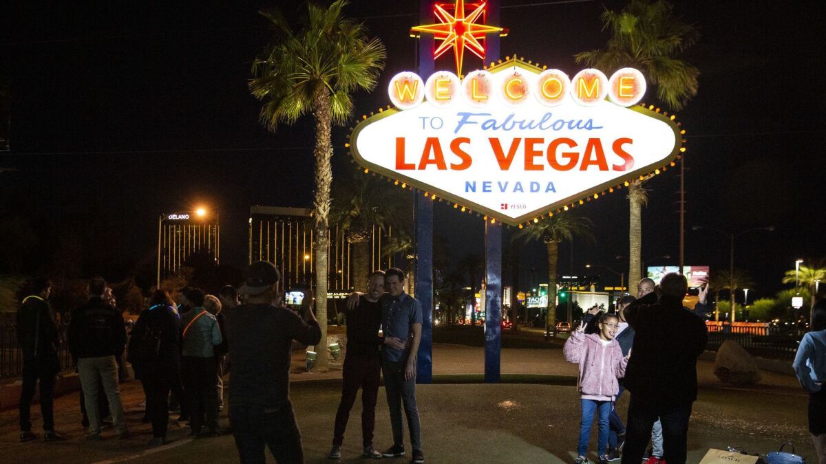 People pose for pictures at the The Las Vegas sign on March 21, 2019 in Las Vegas.