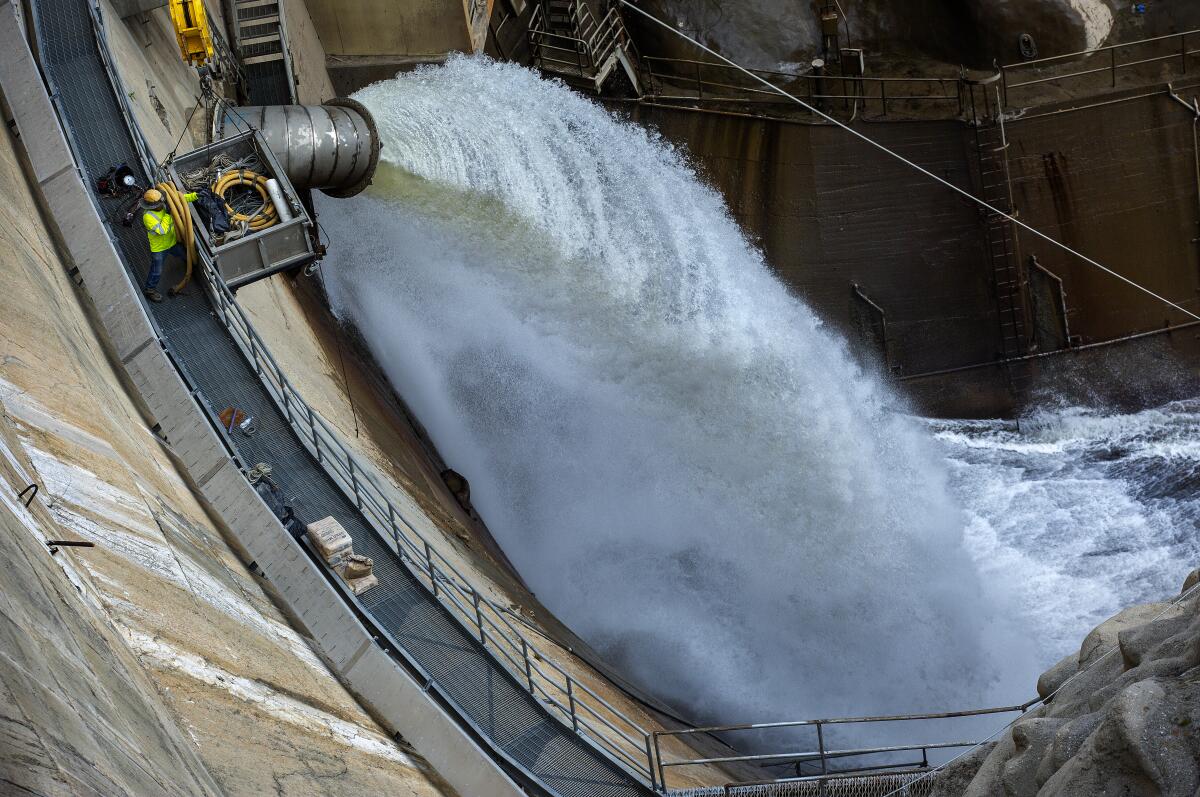 Water spews from a dam's outfall pipe.