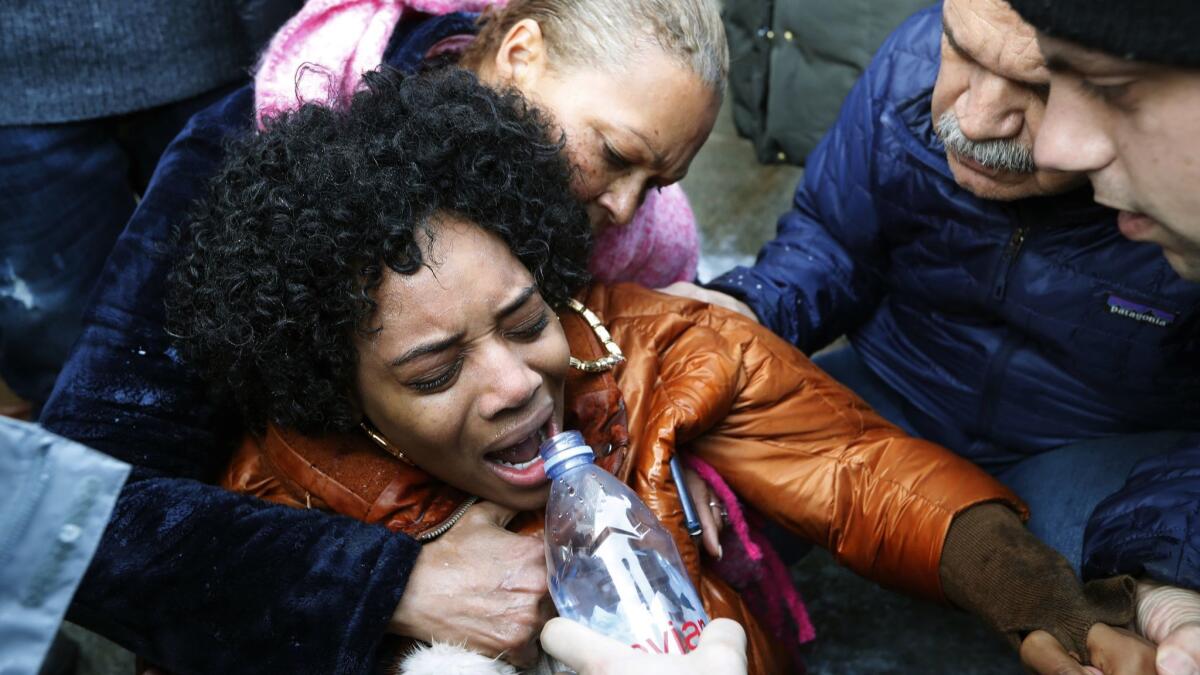A woman is helped after she was pepper sprayed during a protest Sunday at the Metropolitan Detention Center in Brooklyn, N.Y.