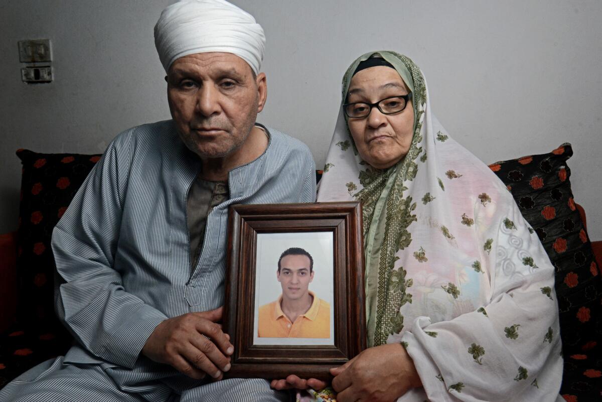Abdel Shakour Abou Zeid and his wife hold a photo of their imprisoned son.