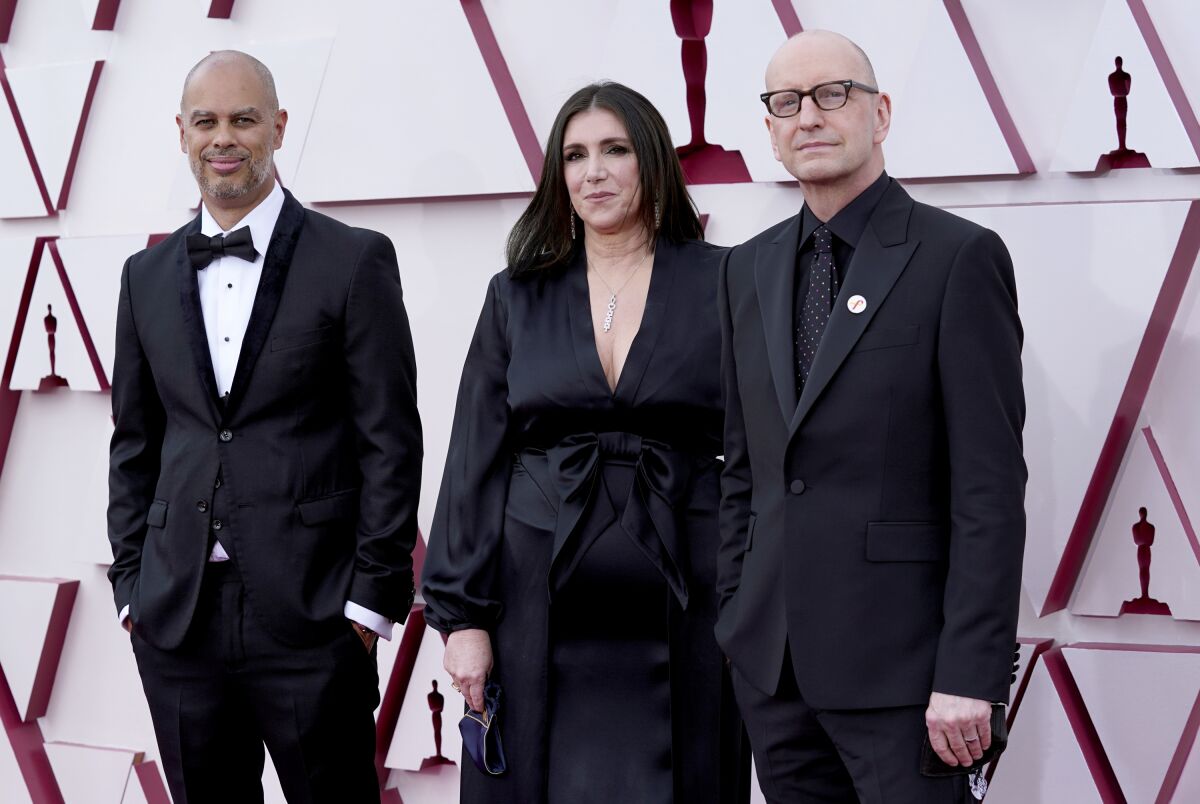 Jesse Collins Stacey Sher and Steven Soderbergh, in black formal wear, pose for a picture.