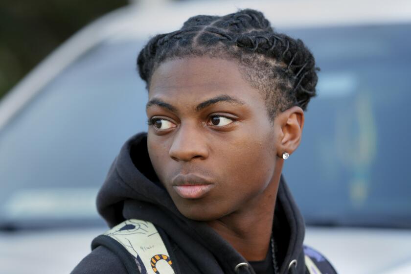 FILE - Darryl George, a 17-year-old junior, before walking across the street to go into Barbers Hill High School after serving a 5-day in-school suspension for not cutting his hair, Sept. 18, 2023, in Mont Belvieu, Texas. A trial is set to be held Thursday, Feb. 21, 2024, to determine if George can continue being punished by his district for refusing to change his hairstyle, which he and his family say is protected by a new state law that prohibits race-based hair discrimination. (AP Photo/Michael Wyke, File)