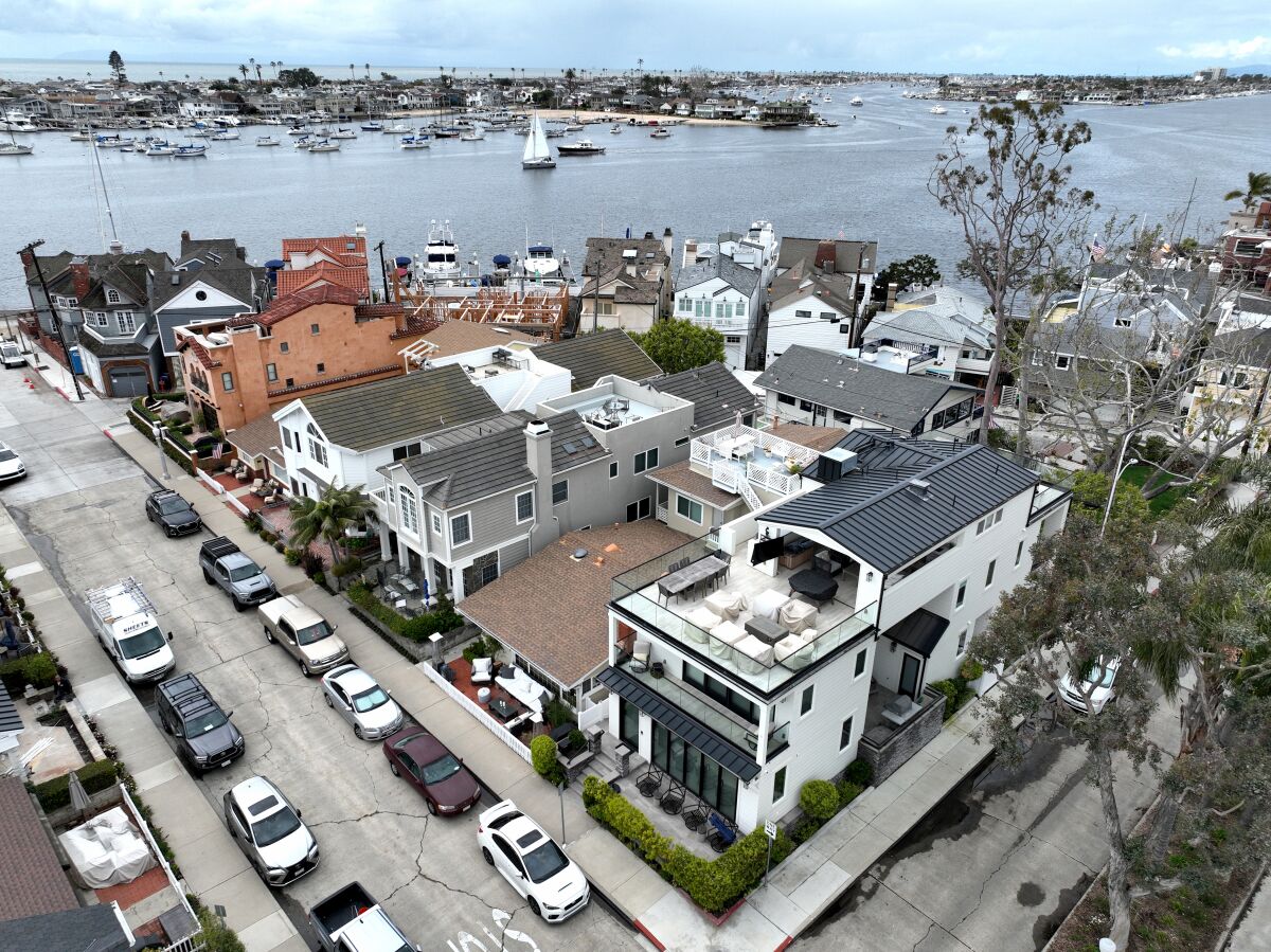 An aerial view of a cluster of Balboa Island homes backed by the seacoast.