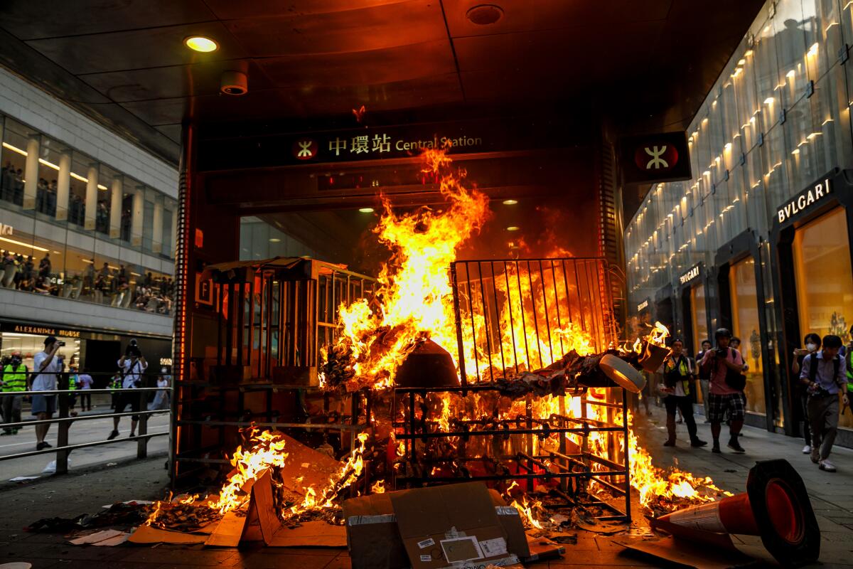 Fire set by protesters blocks the entrance to the MTR Central station stop in Hong Kong on Sunday.