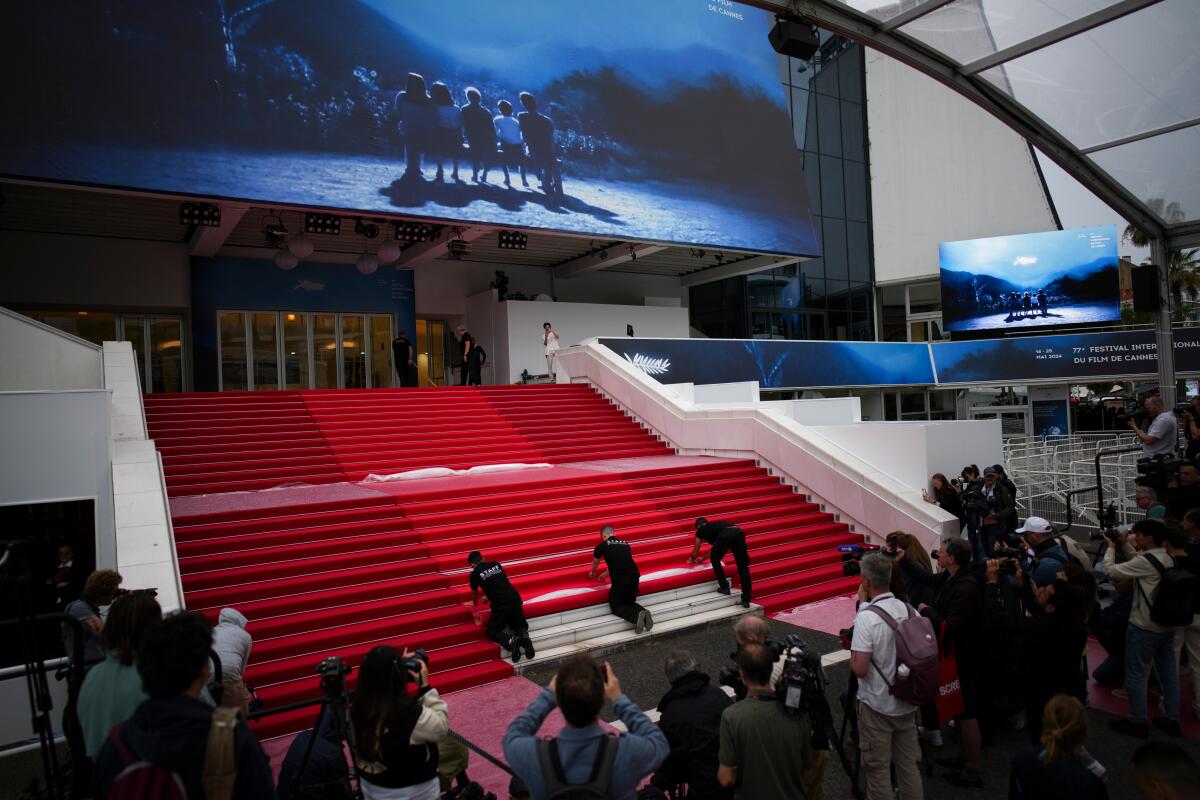 Festival workers unroll the final piece of the red carpet on the empty main staircase at the Cannes Film Festival