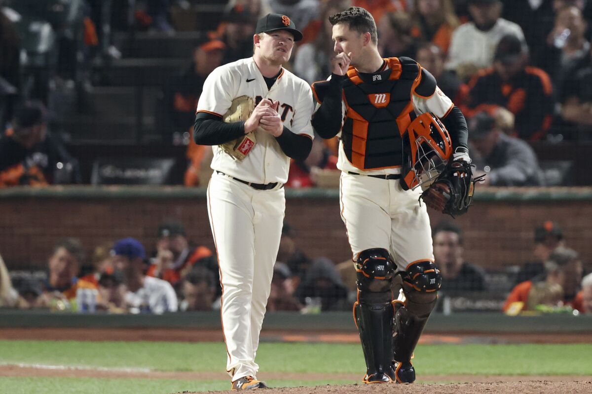 San Francisco Giants starting pitcher Logan Webb and catcher Buster Posey chat during the fourth inning.