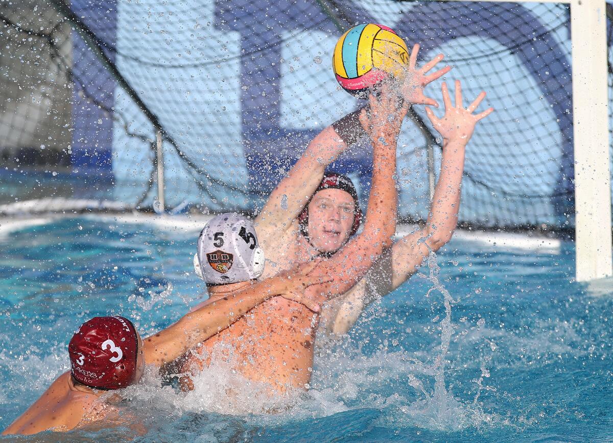 Huntington Beach's Chase Dodd (5) tries to get a shot off as Laguna Beach's August Renezeder (3) defends during a Surf League match on Wednesday at Corona del Mar High.