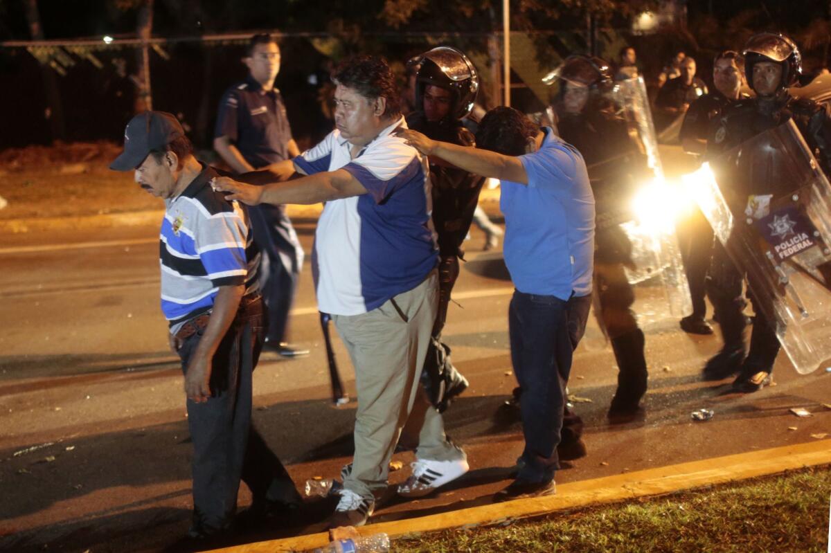Mexican police detain teachers and their relatives during their protest in Acapulco, in Guerrero state, late Tuesday.