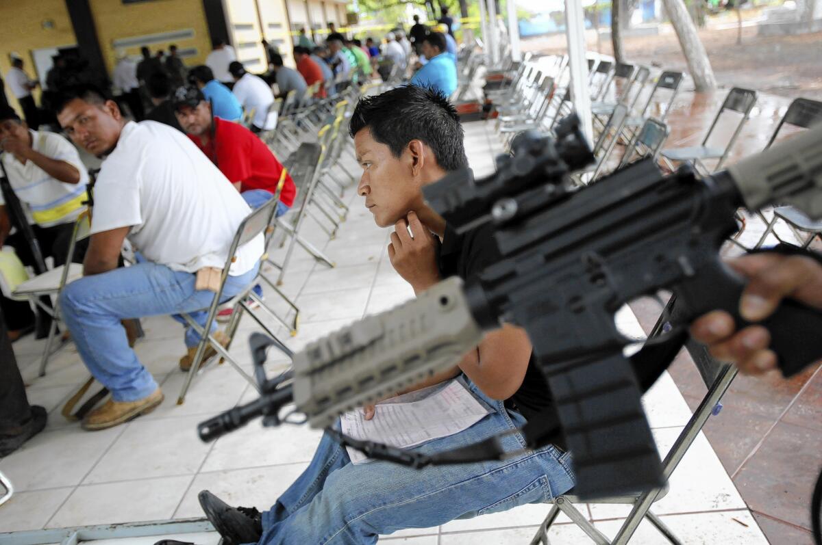 Members of "self-defense" groups wait to register their weapons in Apatzingan, Mexico, before a federally imposed deadline.