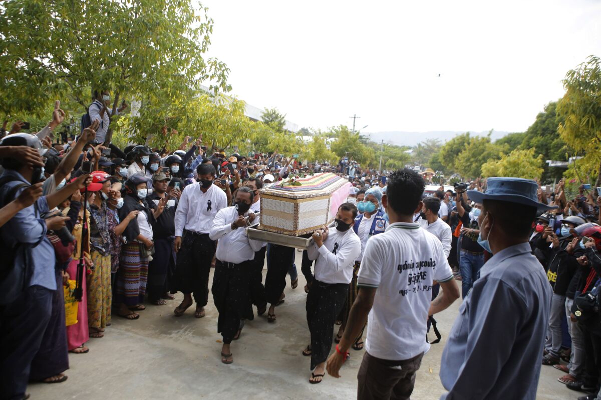 People carry a casket through a crowd.