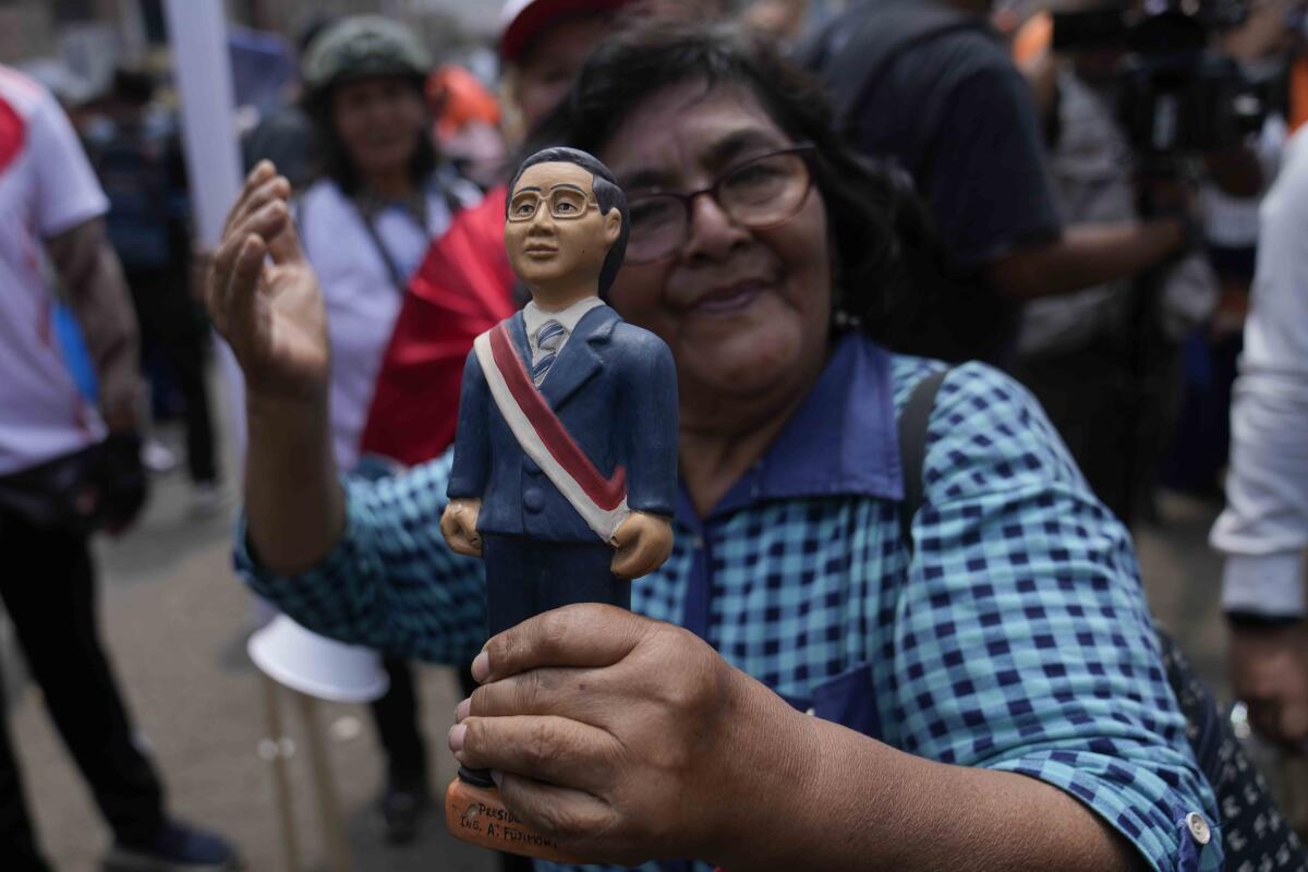 Una simpatizante sostiene un muñeco que representa al expresidente peruano Alberto Fujimori.