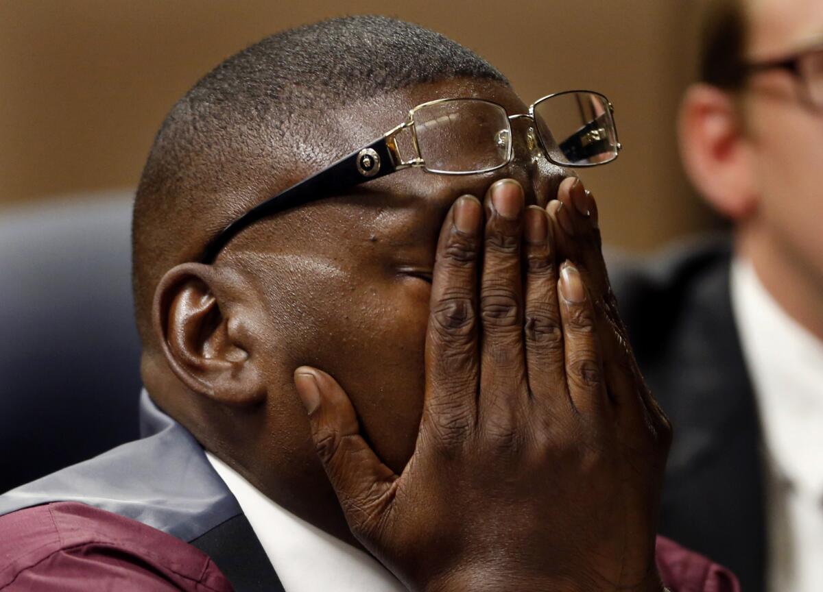 Reggie Cole covers his face while he listens to testimony in a Compton court.