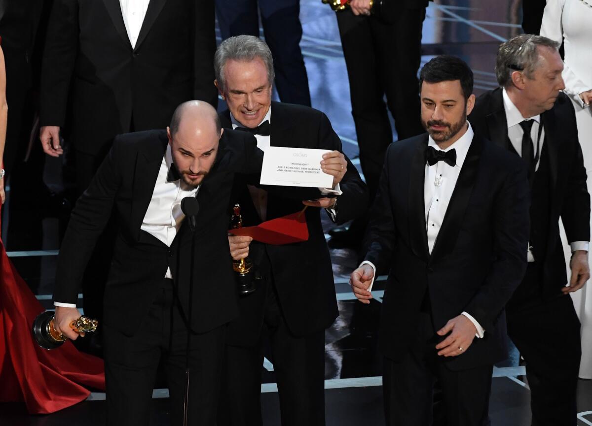 El productor de 'La La Land' Jordan Horowitz sostiene la tarjeta donde está el nombre de la cinta ganadora a la Mejor Película 'Moonlight' y a su lado está el actor Warren Beatty y el maestro de ceremonias Jimmy Kimmel.