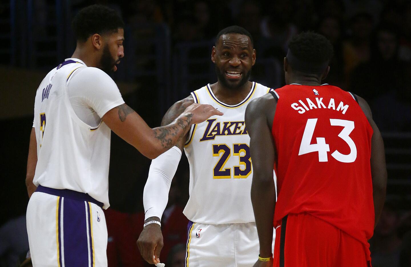 Lakers forward LeBron James (23) and Raptors forward Pascal Siakam have a few words for each other.