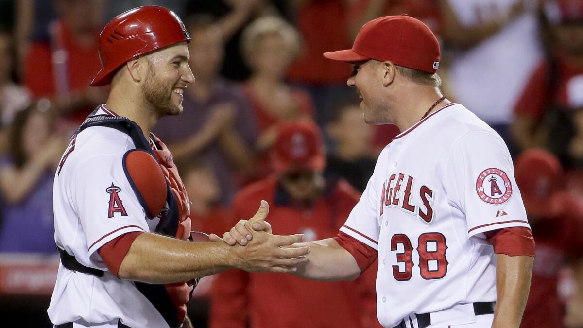 Angels catcher Chris Iannetta, left, and closer Joe Smith celebrate the team's 5-2 win over the Toronto Blue Jays at Angel Stadium on Monday.