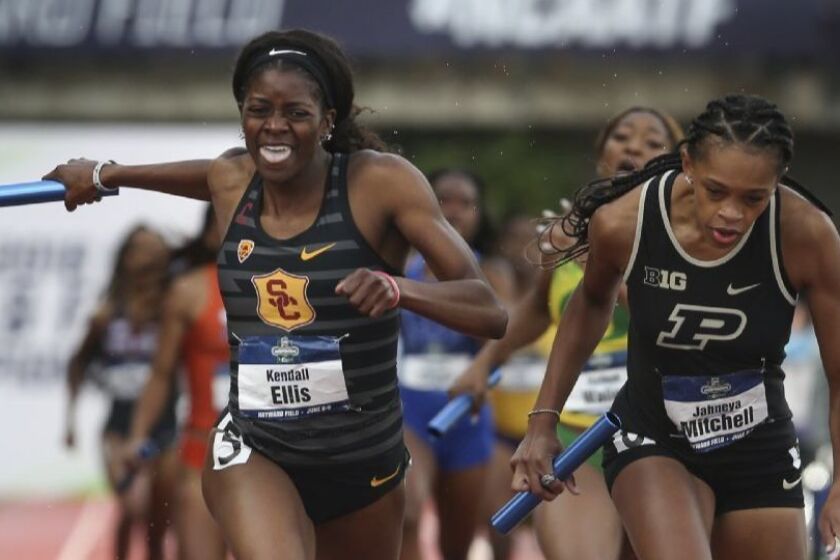 USC's Kendall Ellis crosses the finish line first ahead of Purdue's Jaheya Mitchel in the women's 1,600-meter relay, delivering and incredible comeback for the Trojans' relay team at the NCAA championships.