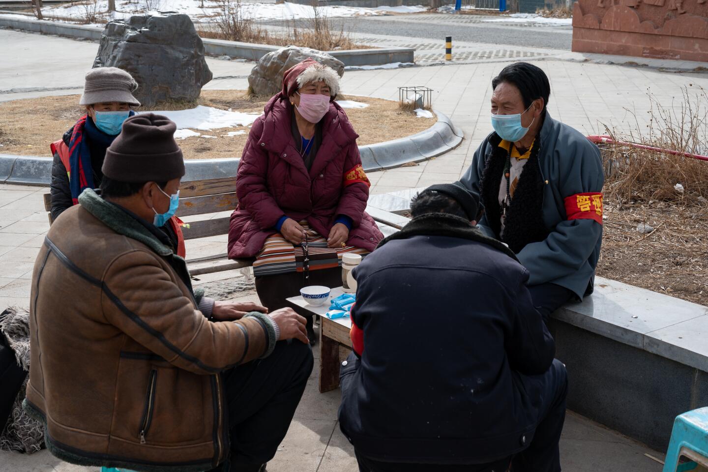 A group of community virus prevention workers in protective masks and red armbands sit in Garze on Feb. 12, 2020.